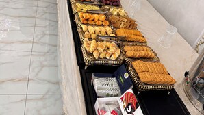 Un bufé con diversas opciones de comida y un espejo decorativo.