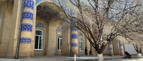 A courtyard with a tiled building featuring arches and blue patterns.