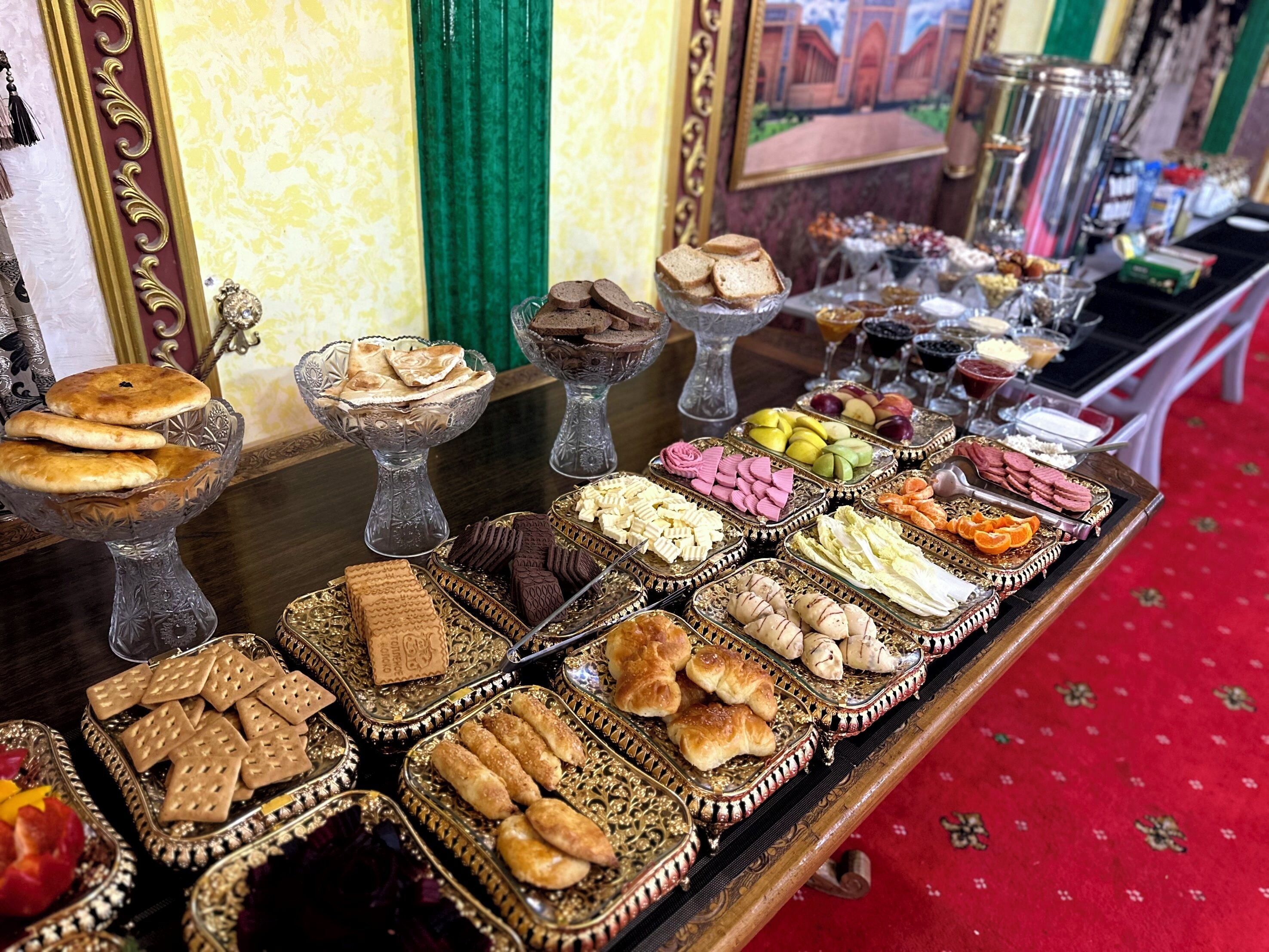 A buffet table with various food items and decorative glassware.