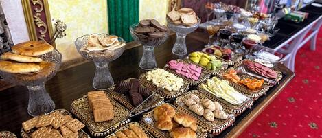 A buffet table with various food items and decorative glassware.
