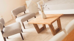 Ein modernes Schlafzimmer im Loft-Stil mit Schräge, einer Holztreppe, einer Schlafcouch und einem Essbereich mit Stühlen und Tisch.