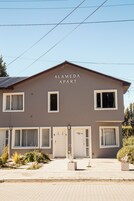 Un edificio de dos pisos con un cartel que dice "ALAMEDA APART".