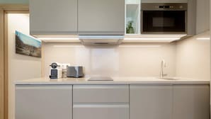 A modern kitchen with a built-in oven, a coffee machine, and a sink.