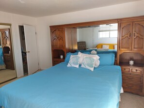 Relax in this serene bedroom with a large bed, a spacious wardrobe, and a bedside table.