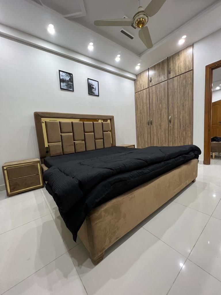 Un dormitorio con una cama grande, un armario y un ventilador de techo.