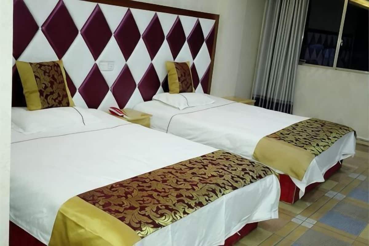 Two twin beds with headboards, white bedding, and patterned bedspreads.