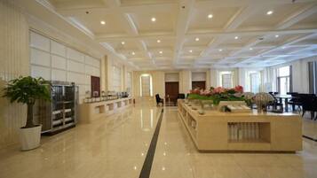 A spacious lobby with a reception desk, seating area, and a piano.
