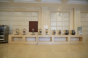Un área de recepción con mostrador, dispensador de agua y máquina de café.