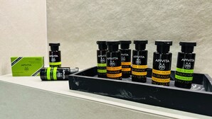A set of black bottles with yellow labels on a shelf.