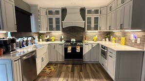 Une cuisine moderne avec des meubles blancs, un îlot central et un plancher en bois.