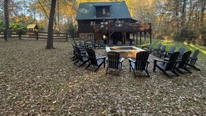 Un chalet doté d’une terrasse, de meubles de jardin et d’un foyer extérieur.