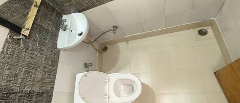 A bathroom with a toilet, sink, and shower.