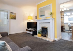 A living room with a fireplace, a television, and a sofa. - 3 Bed House - Sleeps 6 - Parking - Pets - Garden (Rowlands Gill)