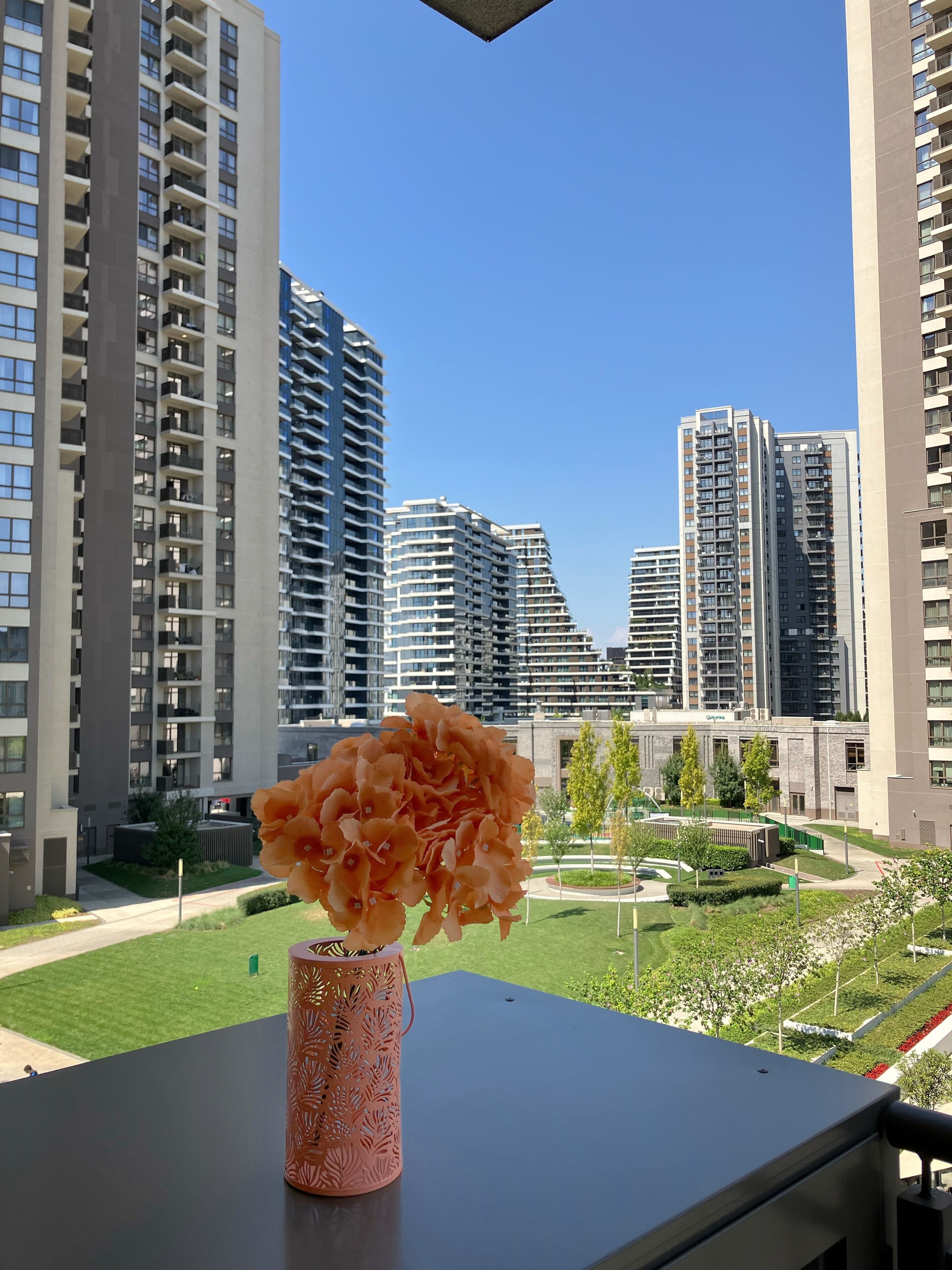A modern building with a clear view of tall residential towers in the background.