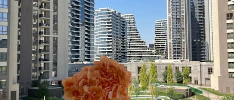 A modern building with a clear view of tall residential towers in the background.