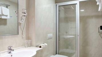 A modern bathroom with a large sink, toilet, and glass shower enclosure.
