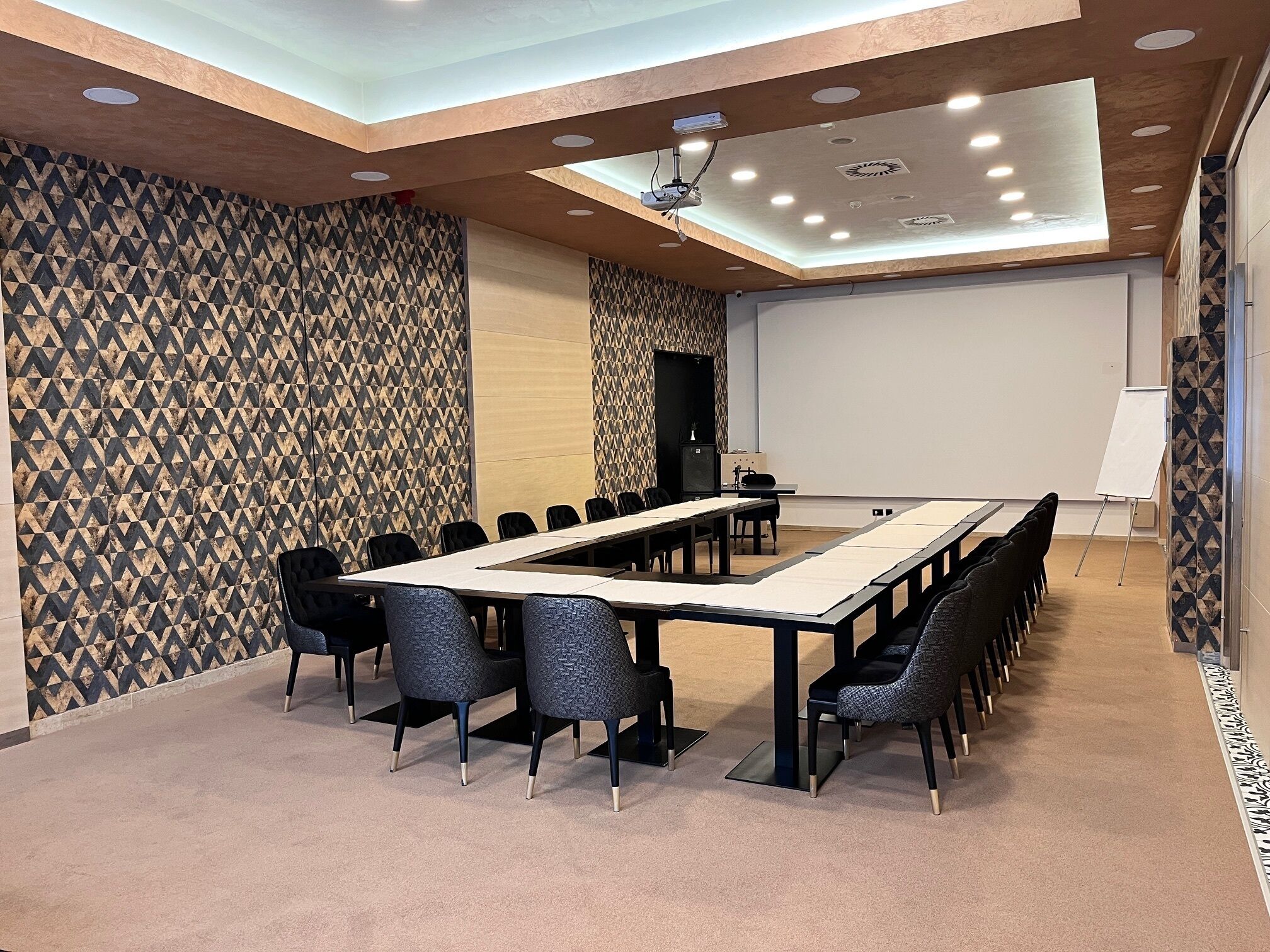 A conference room with a long table, chairs, a projector, and a whiteboard.