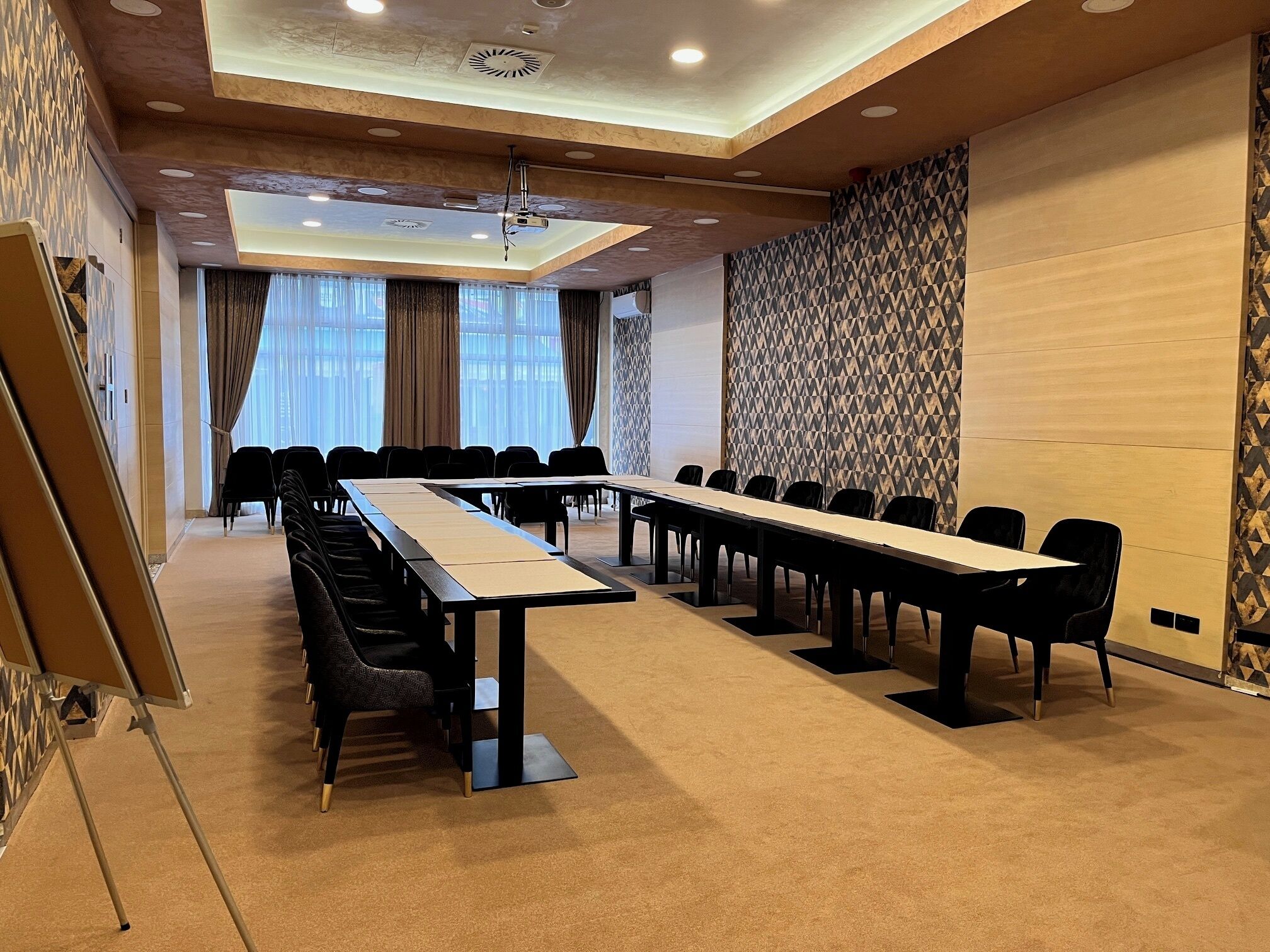 A conference room with a long table, chairs, and a projector.