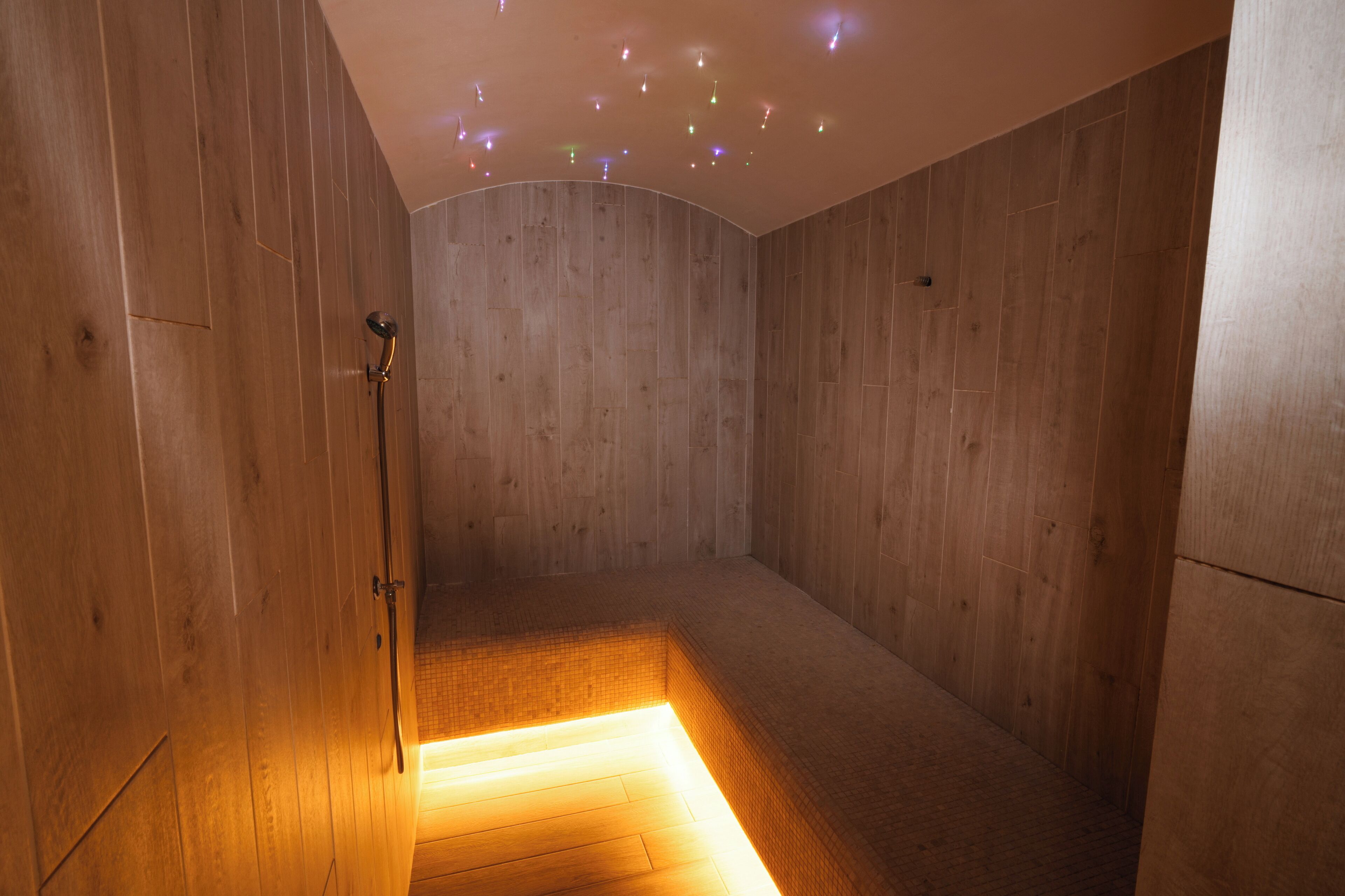 A wooden room with a built-in bench and a shower area.