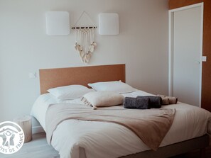 A neatly made bed with a headboard, pillows, and a blanket.