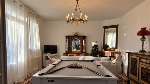 A living room with a pool table, a television, a Christmas tree, and a chandelier. - Spacious Home with Garden, WiFi, and Games Room Near Dordogne's Best Sights (Payzac)