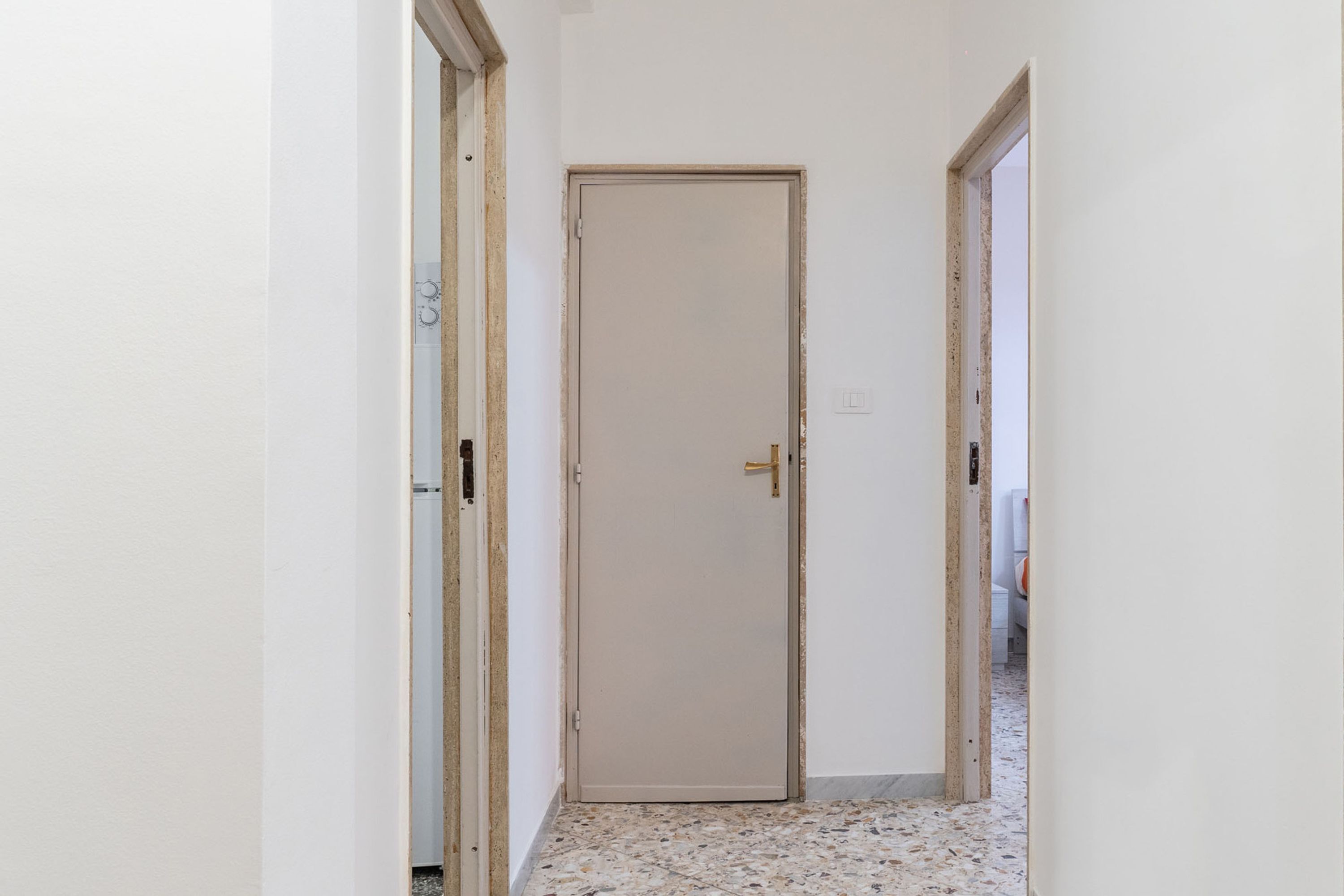 A narrow hallway with a closed door at the end.