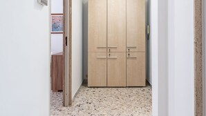 A hallway with a wooden wardrobe, a tiled floor, and a door leading to another room. - Bari Station Classic Apartment by Wonderful Italy (Bari)