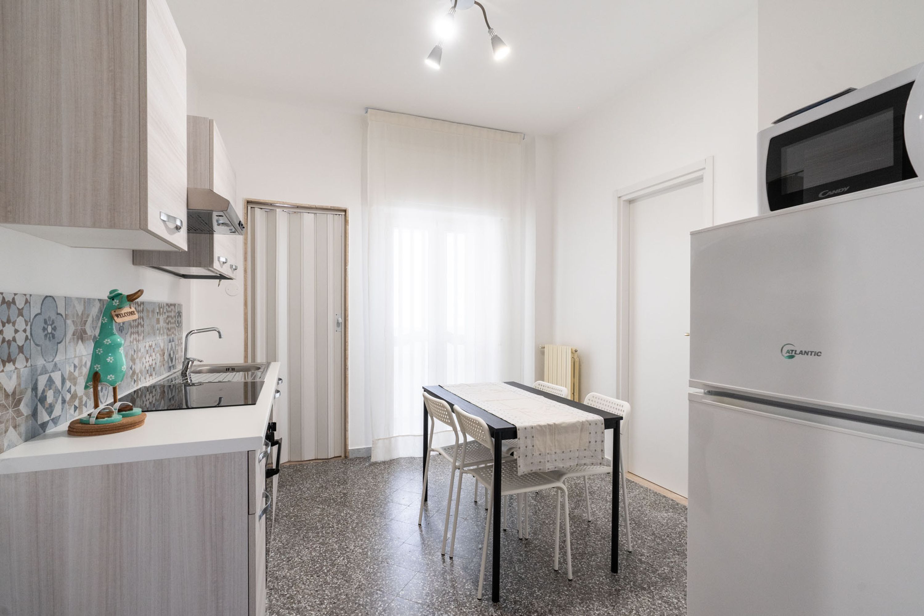A modern kitchen with a white countertop, a built-in microwave, and a refrigerator.