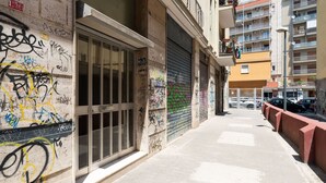 A narrow alleyway with graffiti on walls and a closed shutter door. - Bari Station Classic Apartment by Wonderful Italy (Bari)
