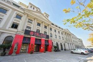 Un edificio grande e histórico con una entrada destacada y un cartel que indica que es un hotel.