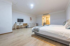A modern hotel room with a large bed, a desk, a chair, and a television. - Ningbo jinfu hotel apartment (Ningbo)