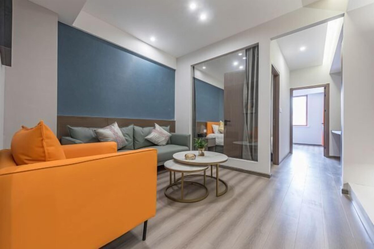 A modern living room with a sofa, a coffee table, and a large mirror.