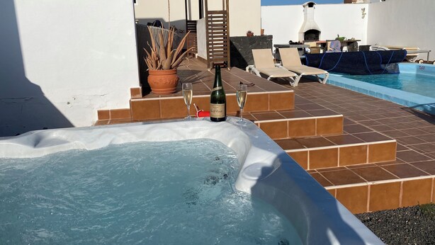 Ein Whirlpool mit Pool, Sitzgelegenheiten im Freien und ein Grillbereich.