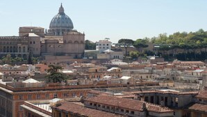 A cityscape with a prominent dome structure, likely a historical or religious building, surrounded by densely packed buildings with varied architectural styles. - TERRAZZA SAN PIETRO EXCLUSIVE APARTMENT DE LUXE IN ROME  (Roma)