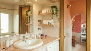 A bathroom with a large sink, a mirror, shelves with toiletries, and a washing machine. - TERRAZZA SAN PIETRO EXCLUSIVE APARTMENT DE LUXE IN ROME  (Roma)