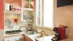 A kitchen with a gas stove, sink, and a coffee machine. - TERRAZZA SAN PIETRO EXCLUSIVE APARTMENT DE LUXE IN ROME  (Roma)