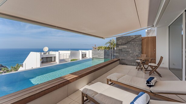 A modern balcony with a pool overlooking the ocean, furnished with lounge chairs and a table. - Magnífico Apartamento con Piscina Privada y Vistas al mar en los Gigantes (Acantilados de Los Gigantes)
