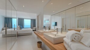 A modern hotel room with a large bed, a wooden vanity with a mirror, and a view of the sea. - Magnífico Apartamento con Piscina Privada y Vistas al mar en los Gigantes (Acantilados de Los Gigantes)