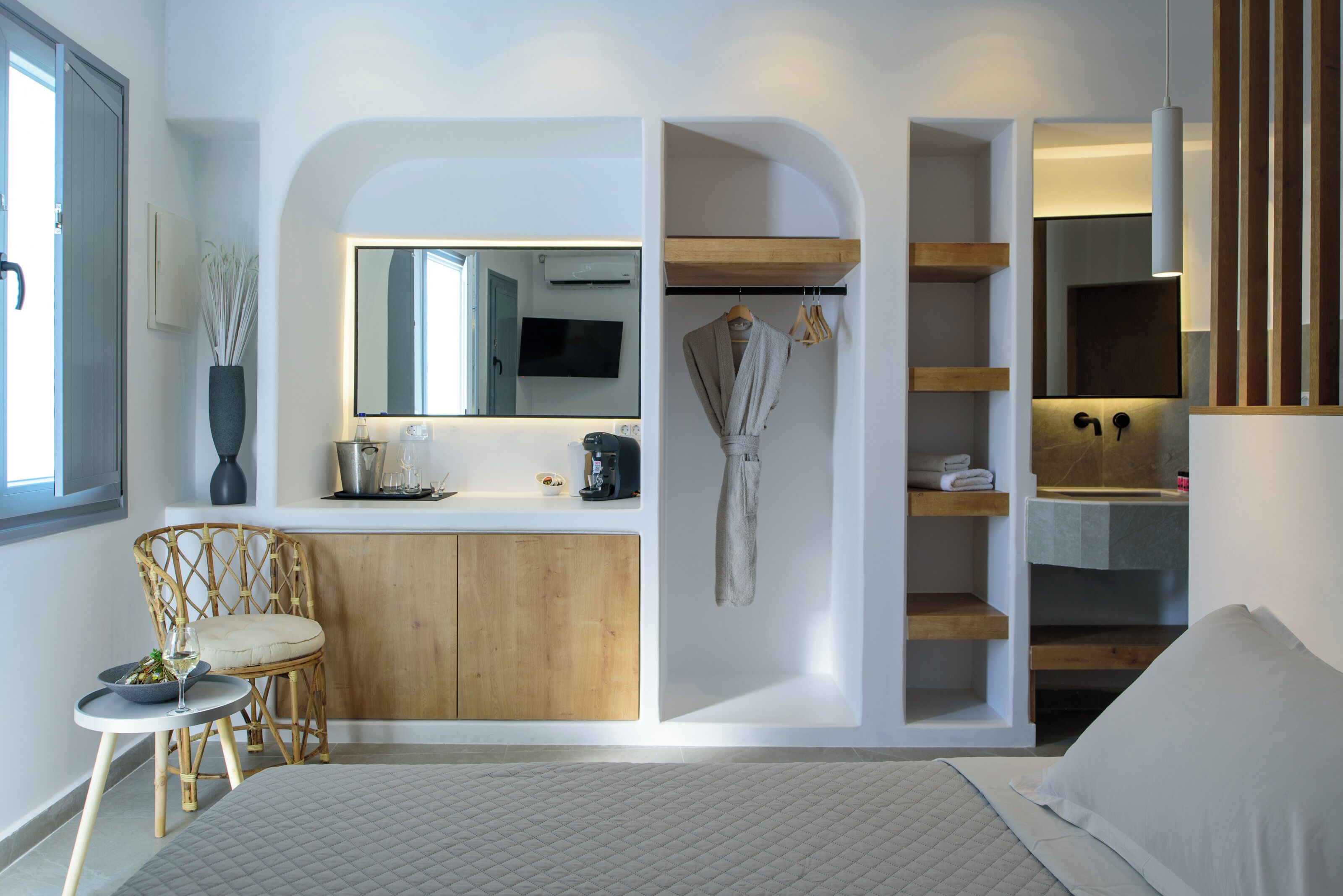 Een moderne slaapkamer met een bed, nachtkastje, stoel, inbouwkleedkast en spiegel.