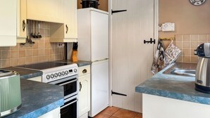 A compact kitchen with a stove, oven, and a refrigerator.