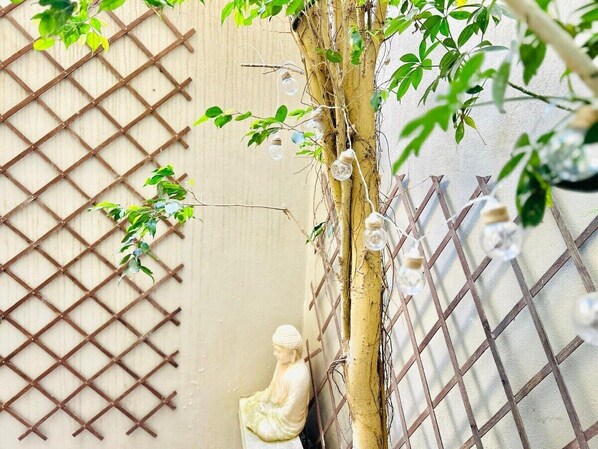 A traditional Japanese garden with a bamboo fence, a small statue, and a tree with hanging glass orbs. - Private rooftop terrace + BBQ + Prime location! (Tas-Sliema)