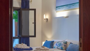 Hotellihuone, jossa on sänky, tyynyjä ja ikkuna, jossa on verhot.