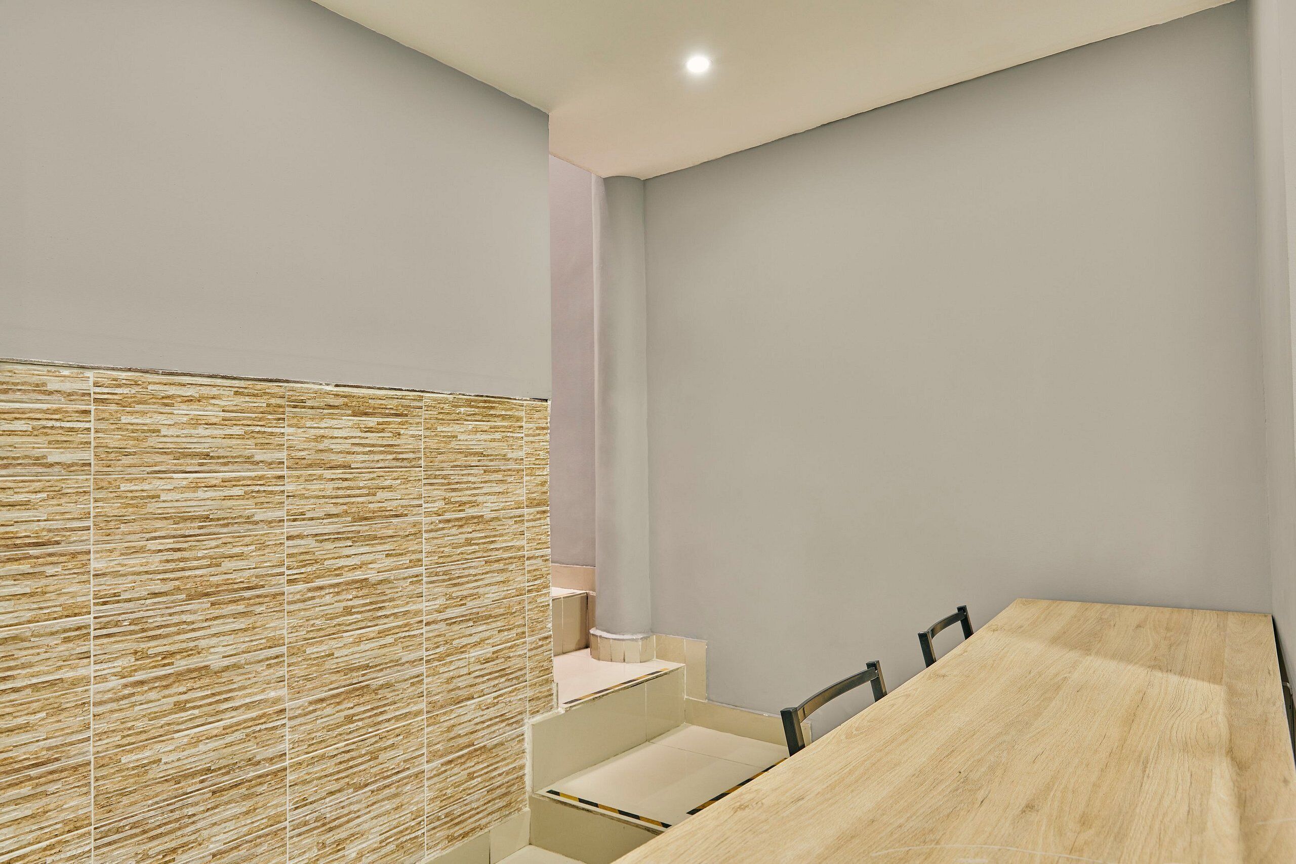 Une salle de réunion moderne, dotée d’une table en bois, de chaises et d’un mur à texture.