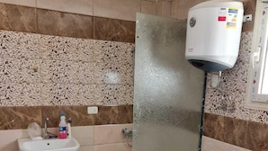 Une salle de bain avec un lavabo, des toilettes et une douche.