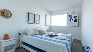 Una camera d'albergo con un letto, cuscini, una mappa, un cappello e un cartello con su scritto 'Stay Hall short term rental'.