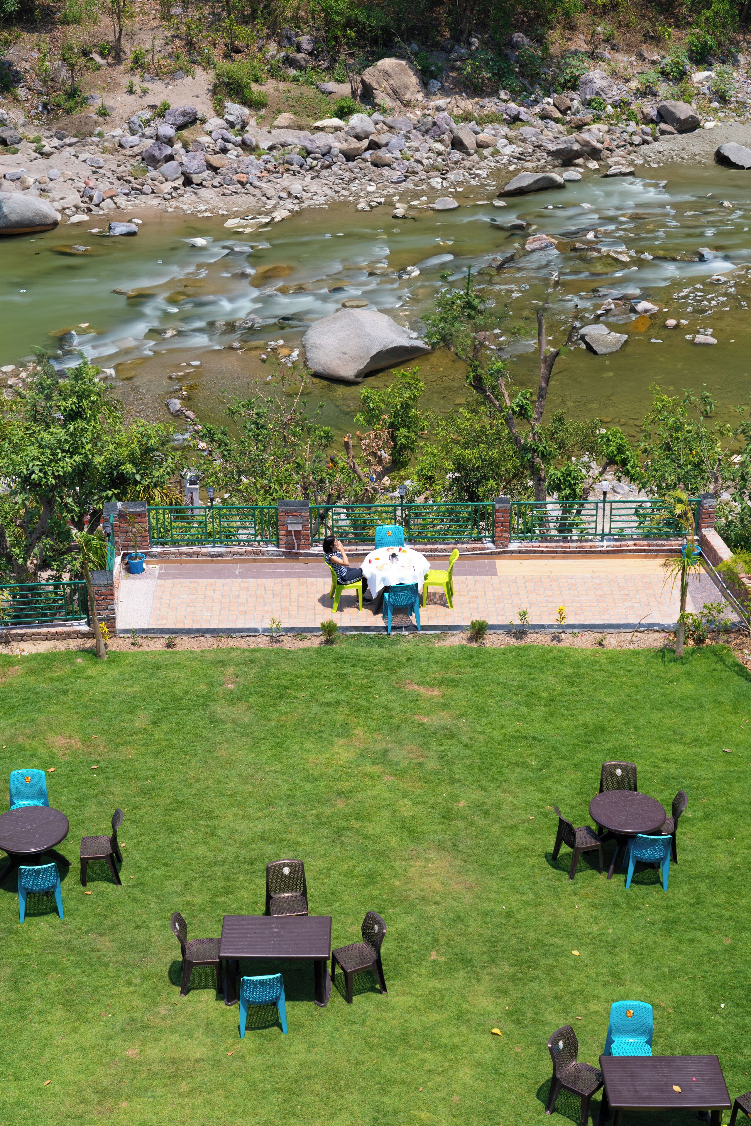 A riverside patio with outdoor seating and a view of the river.