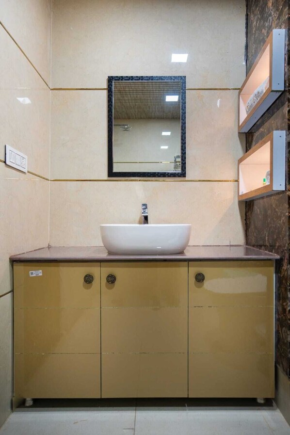Une salle de bain avec un meuble-lavabo beige, un lavabo blanc et un miroir au-dessus.
