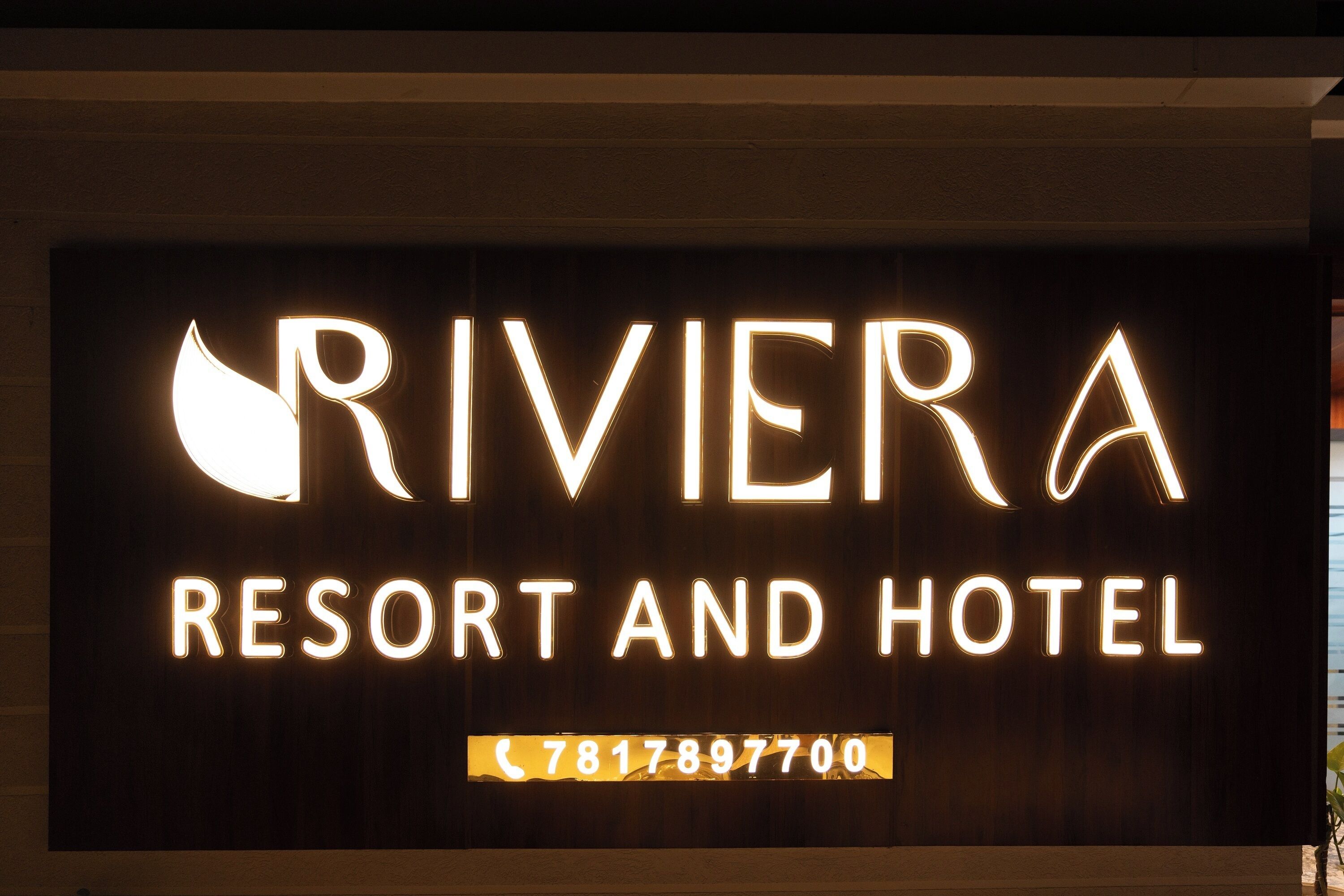A sign for Riviera Resort and Hotel with a phone number.