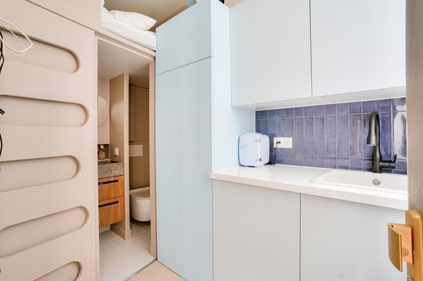 A compact kitchenette with a built-in oven, a sink, and a small countertop.