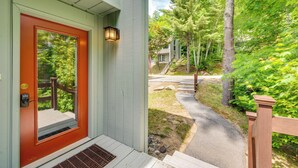 Una casa con una porta rossa, un portico e un vialetto che conduce a una scala.